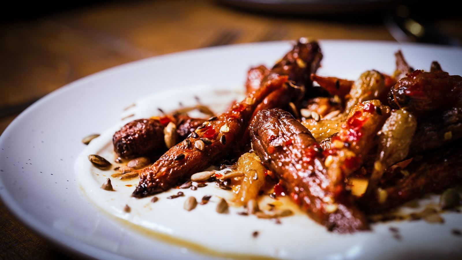 Close-up of glazed heritage carrots with chilli and toasted seeds